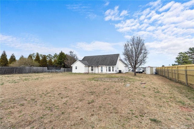 rear view of house featuring a fenced backyard