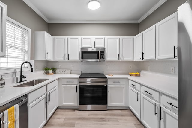 131 Cricketgrass Dr, Cary, NC 27513 - kitchen with appliances with stainless steel finishes, a sink, crown molding, white cabinetry, and light countertops