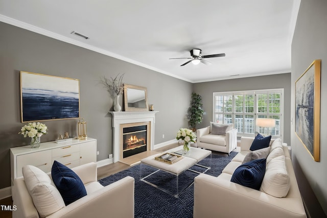131 Cricketgrass Dr, Cary, NC 27513 - living area with ceiling fan, a glass covered fireplace, ornamental molding, baseboards, and wood finished floors