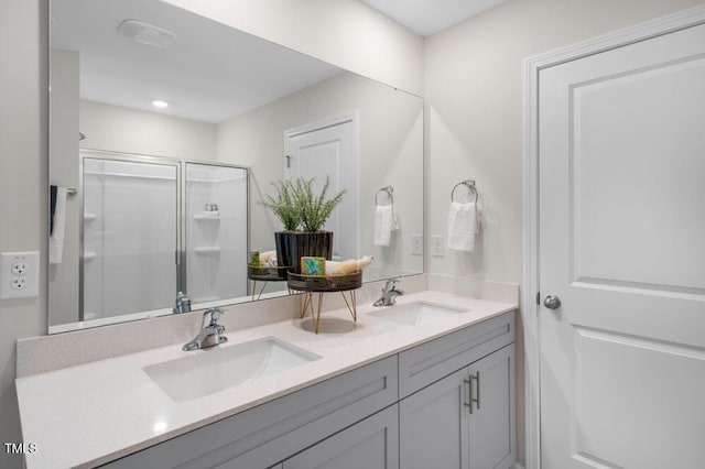 full bath with double vanity, a shower stall, and a sink