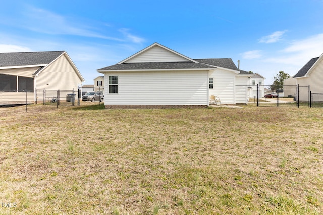 back of property featuring a lawn, fence, and a gate