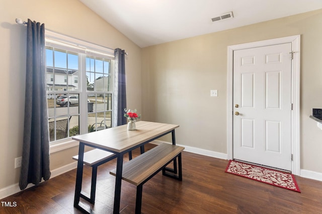 dining space featuring dark wood-style floors, visible vents, vaulted ceiling, and baseboards