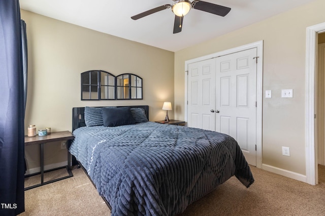 carpeted bedroom featuring a ceiling fan, a closet, and baseboards