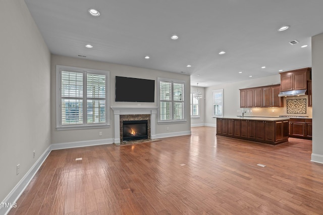 unfurnished living room featuring a wealth of natural light, visible vents, recessed lighting, and light wood-type flooring