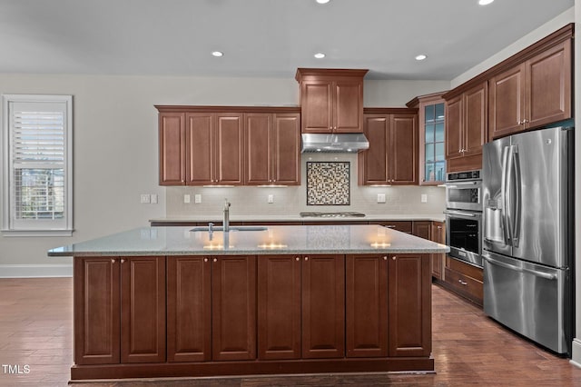 kitchen featuring a sink, stainless steel appliances, under cabinet range hood, and dark wood-style floors