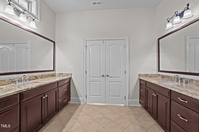 bathroom featuring tile patterned floors, two vanities, visible vents, and a sink