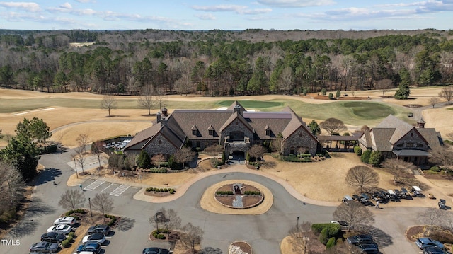 drone / aerial view with view of golf course and a wooded view