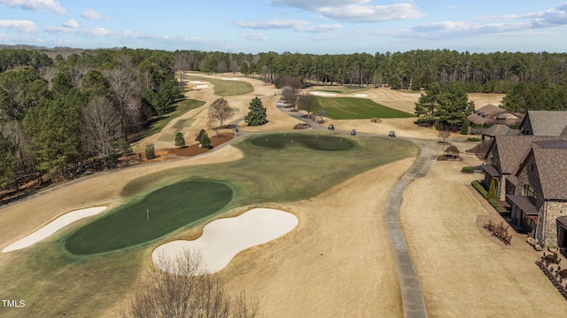 aerial view with view of golf course and a view of trees