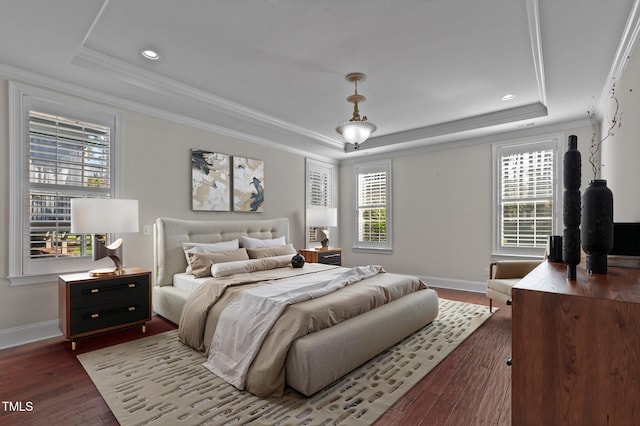 bedroom featuring a raised ceiling, crown molding, multiple windows, and wood finished floors