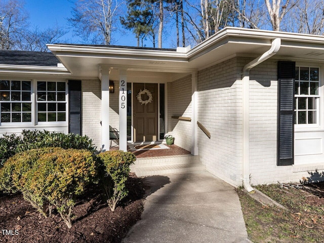 view of exterior entry with brick siding