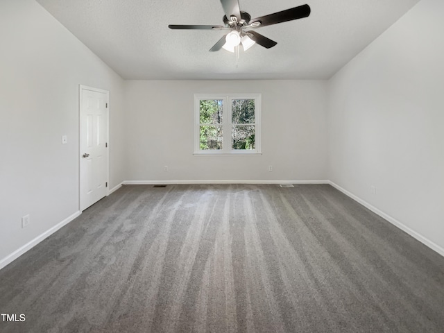 spare room featuring a textured ceiling, ceiling fan, dark carpet, and baseboards