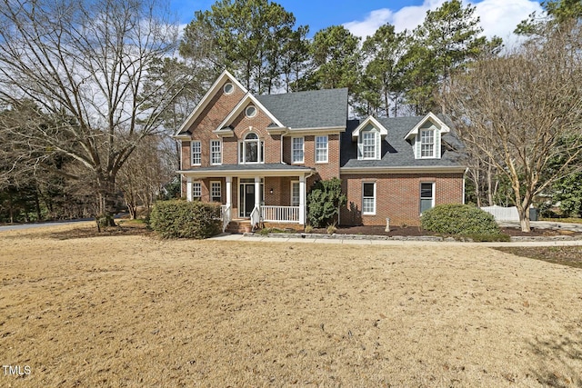 view of front of home with covered porch and brick siding