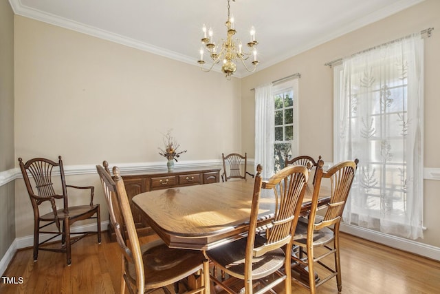 dining room featuring ornamental molding, light wood-type flooring, and baseboards