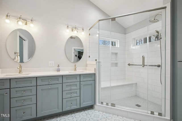 bathroom featuring lofted ceiling, a stall shower, double vanity, and a sink