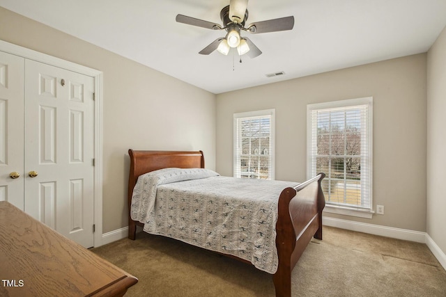 carpeted bedroom featuring multiple windows, visible vents, and baseboards