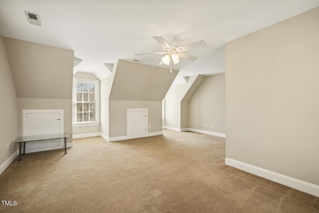 additional living space with light carpet, a ceiling fan, and baseboards