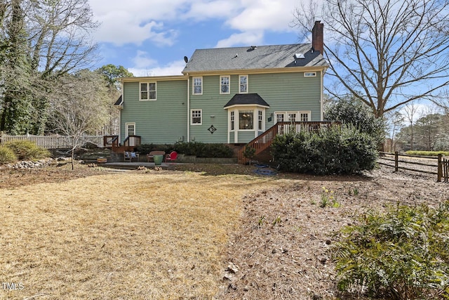 back of property featuring fence and a chimney