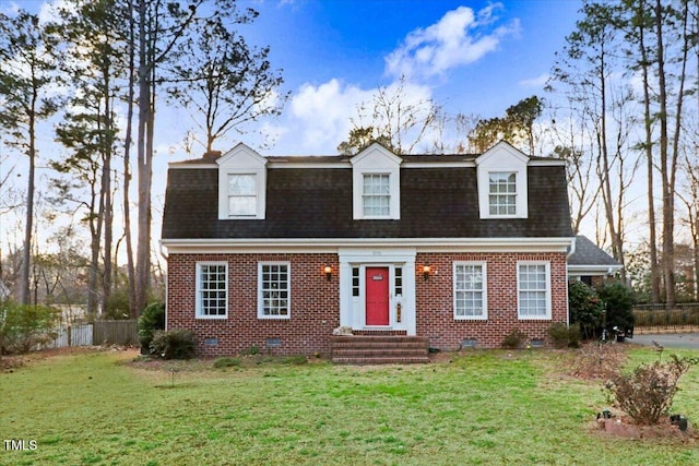 colonial inspired home featuring crawl space, roof with shingles, and brick siding