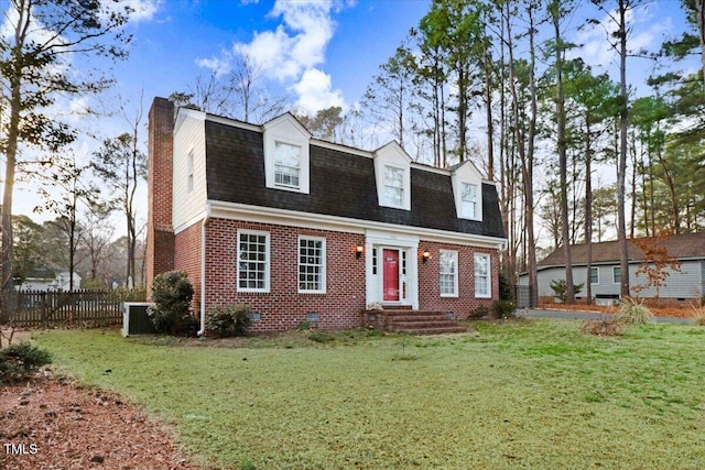 colonial inspired home featuring brick siding, roof with shingles, central air condition unit, a front yard, and fence