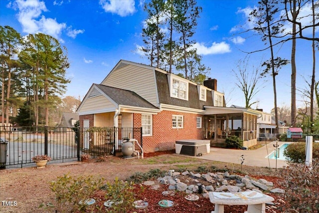 rear view of house featuring brick siding, fence, crawl space, a chimney, and a patio area