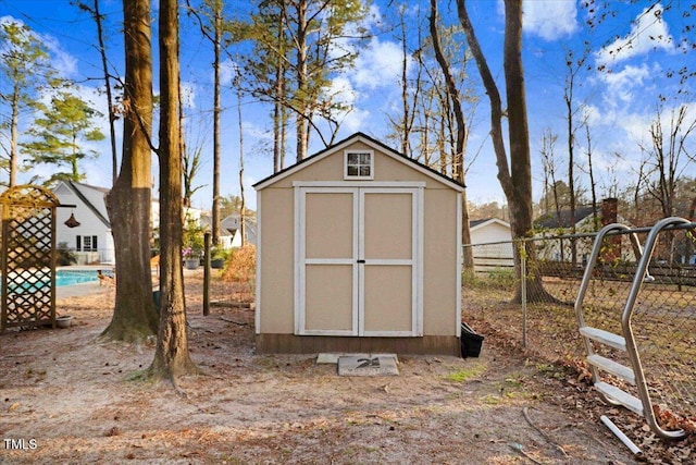 view of shed with fence and a fenced in pool