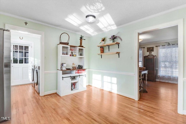 interior space featuring ornamental molding, freestanding refrigerator, light wood-style floors, and open shelves