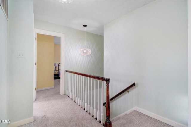 staircase featuring carpet flooring and baseboards