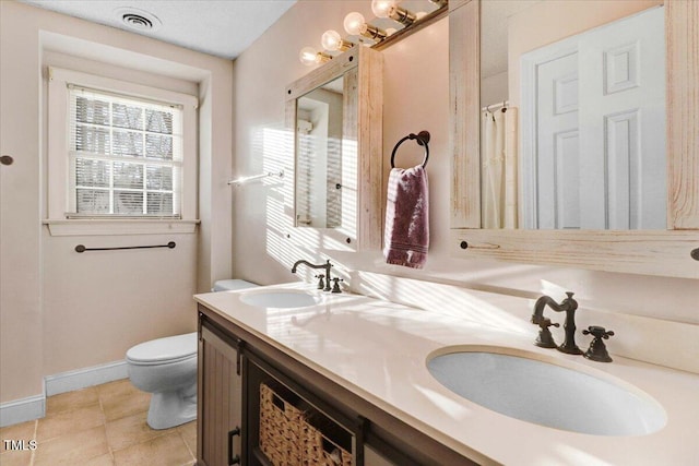 bathroom with toilet, a sink, visible vents, and tile patterned floors