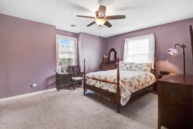 bedroom featuring light carpet, baseboards, multiple windows, and visible vents