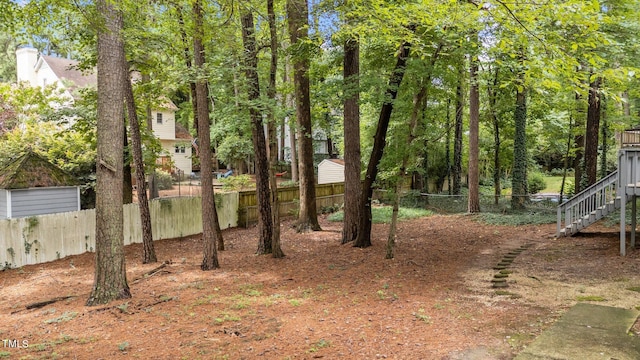 view of yard featuring fence and stairs