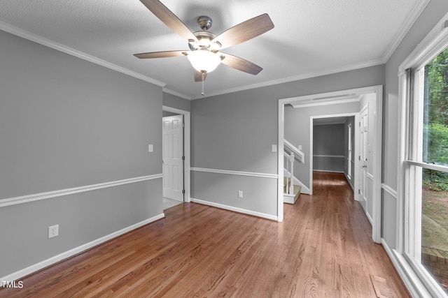 spare room with baseboards, visible vents, ornamental molding, wood finished floors, and a textured ceiling