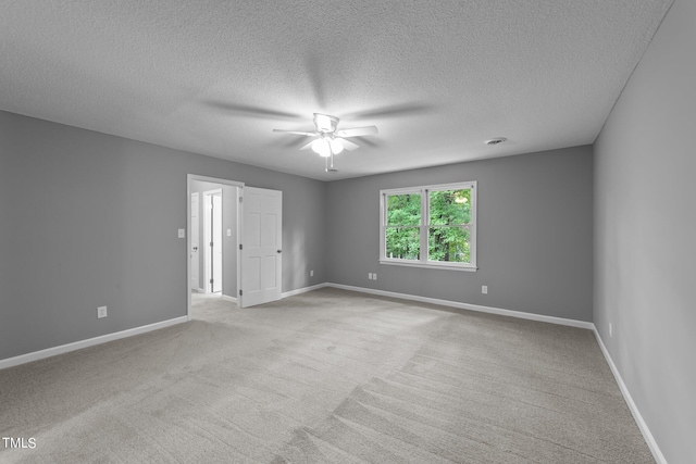 unfurnished room featuring visible vents, baseboards, a ceiling fan, light colored carpet, and a textured ceiling