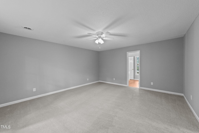 unfurnished room featuring visible vents, a ceiling fan, carpet flooring, a textured ceiling, and baseboards