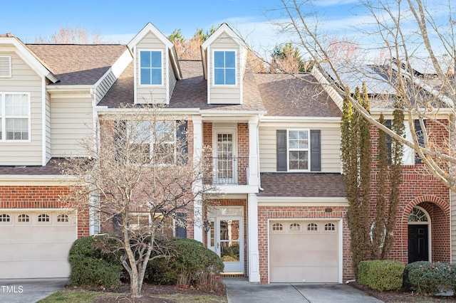 view of front of property featuring an attached garage, brick siding, driveway, and roof with shingles