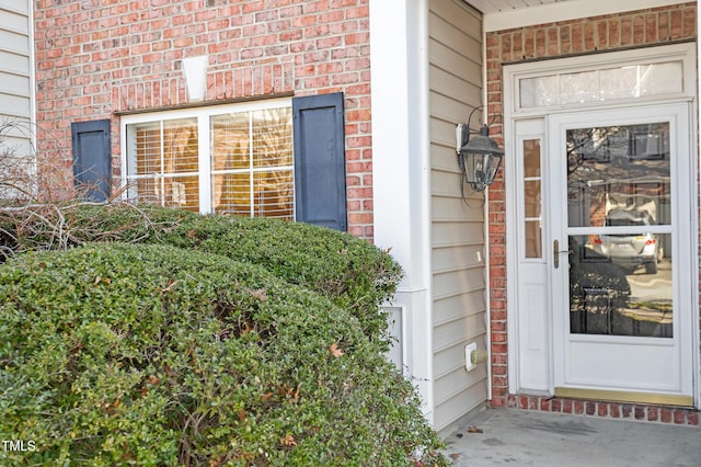 entrance to property featuring brick siding