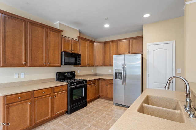 kitchen with black appliances, recessed lighting, brown cabinets, and a sink