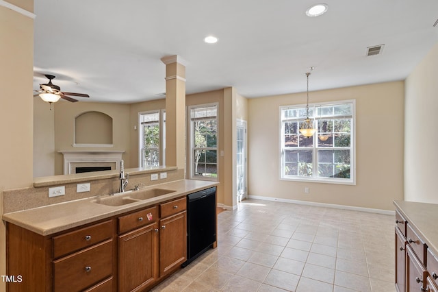 kitchen featuring visible vents, open floor plan, black dishwasher, brown cabinetry, and a sink