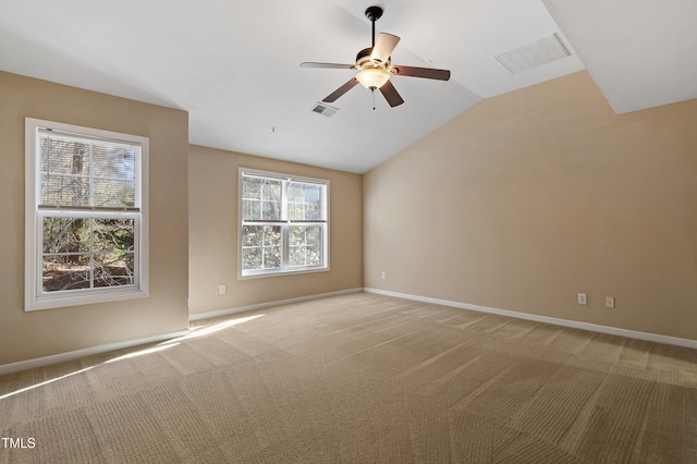 spare room featuring lofted ceiling, baseboards, visible vents, and light carpet