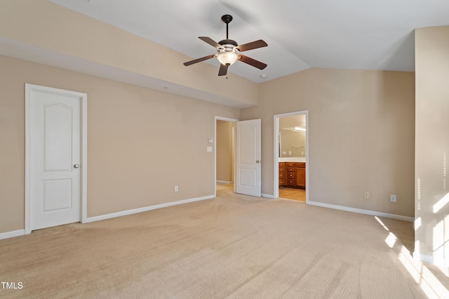 unfurnished bedroom featuring vaulted ceiling, light colored carpet, and baseboards