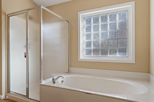 bathroom featuring a bath and a shower stall