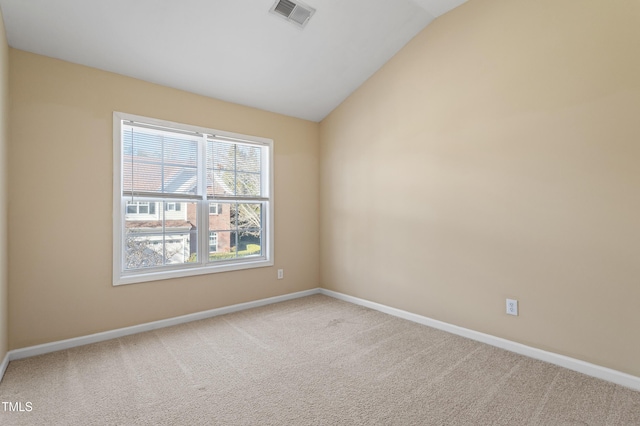 carpeted spare room featuring visible vents, baseboards, and vaulted ceiling