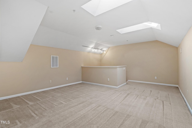 additional living space with lofted ceiling with skylight, baseboards, visible vents, and carpet floors