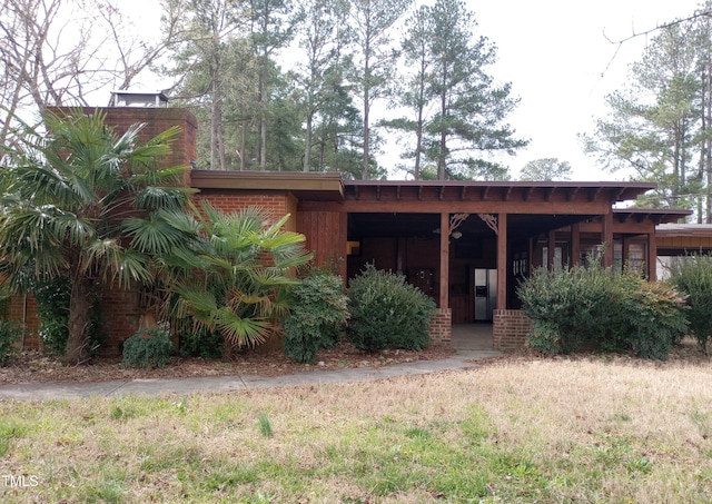 view of front of house featuring brick siding and a chimney