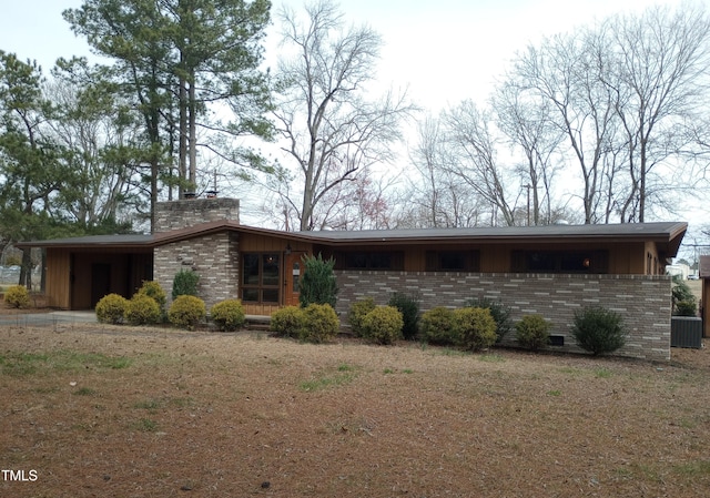 view of front of home with board and batten siding, brick siding, and a chimney