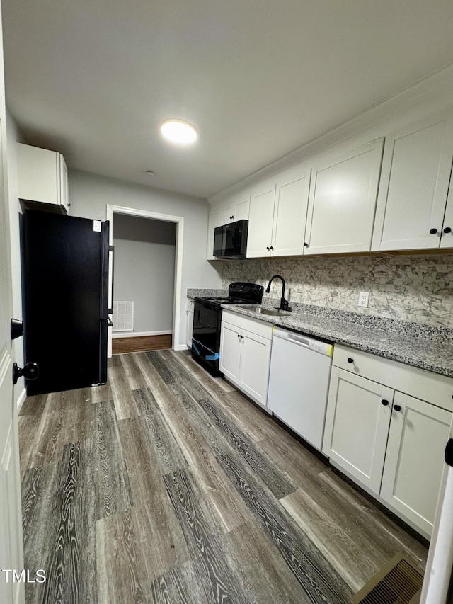 kitchen featuring a sink, visible vents, white cabinets, black appliances, and dark wood finished floors