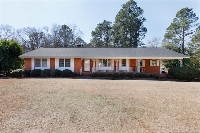 single story home featuring covered porch and brick siding