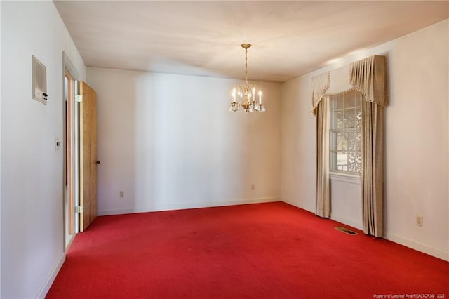 empty room featuring carpet floors, visible vents, baseboards, and an inviting chandelier