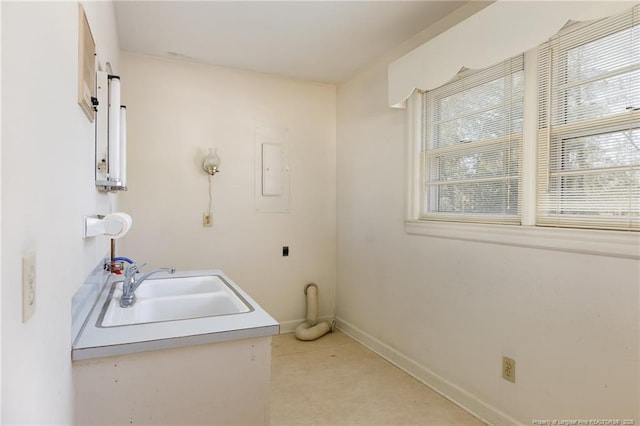 bathroom featuring a sink, electric panel, and baseboards