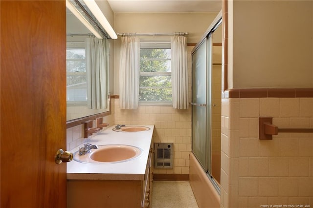 bathroom with heating unit, tile walls, and a sink