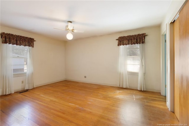 unfurnished room with light wood-style floors, visible vents, and a ceiling fan